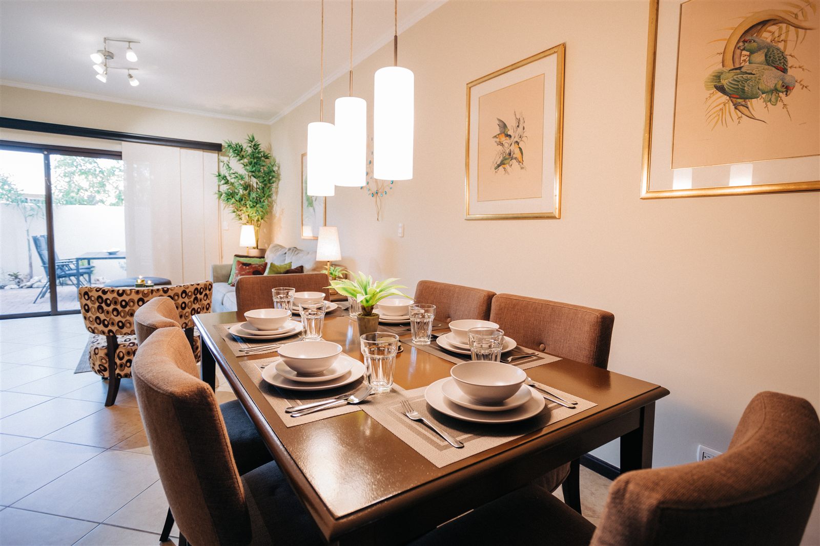 Dining table set for six beside the living room