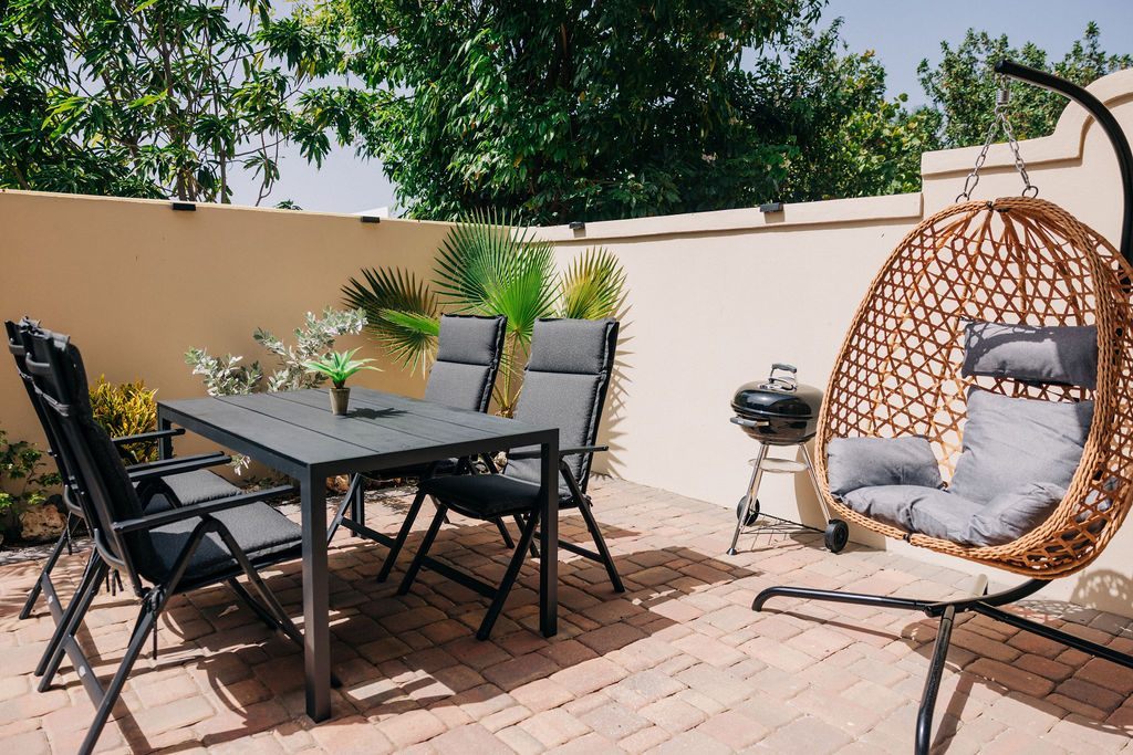 Private patio with dining table, hanging chair and barbecue