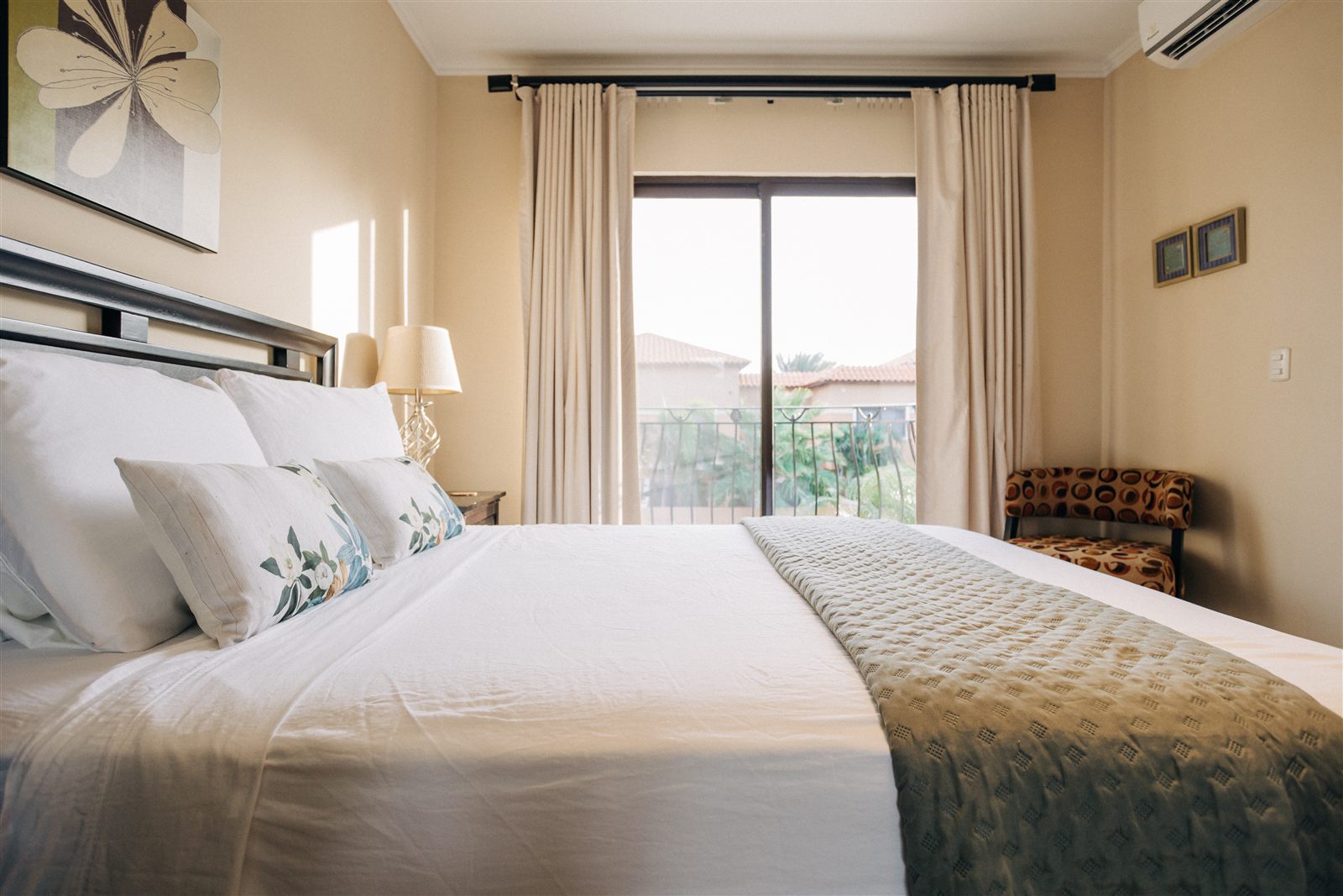 Queen bed beside the balcony doors