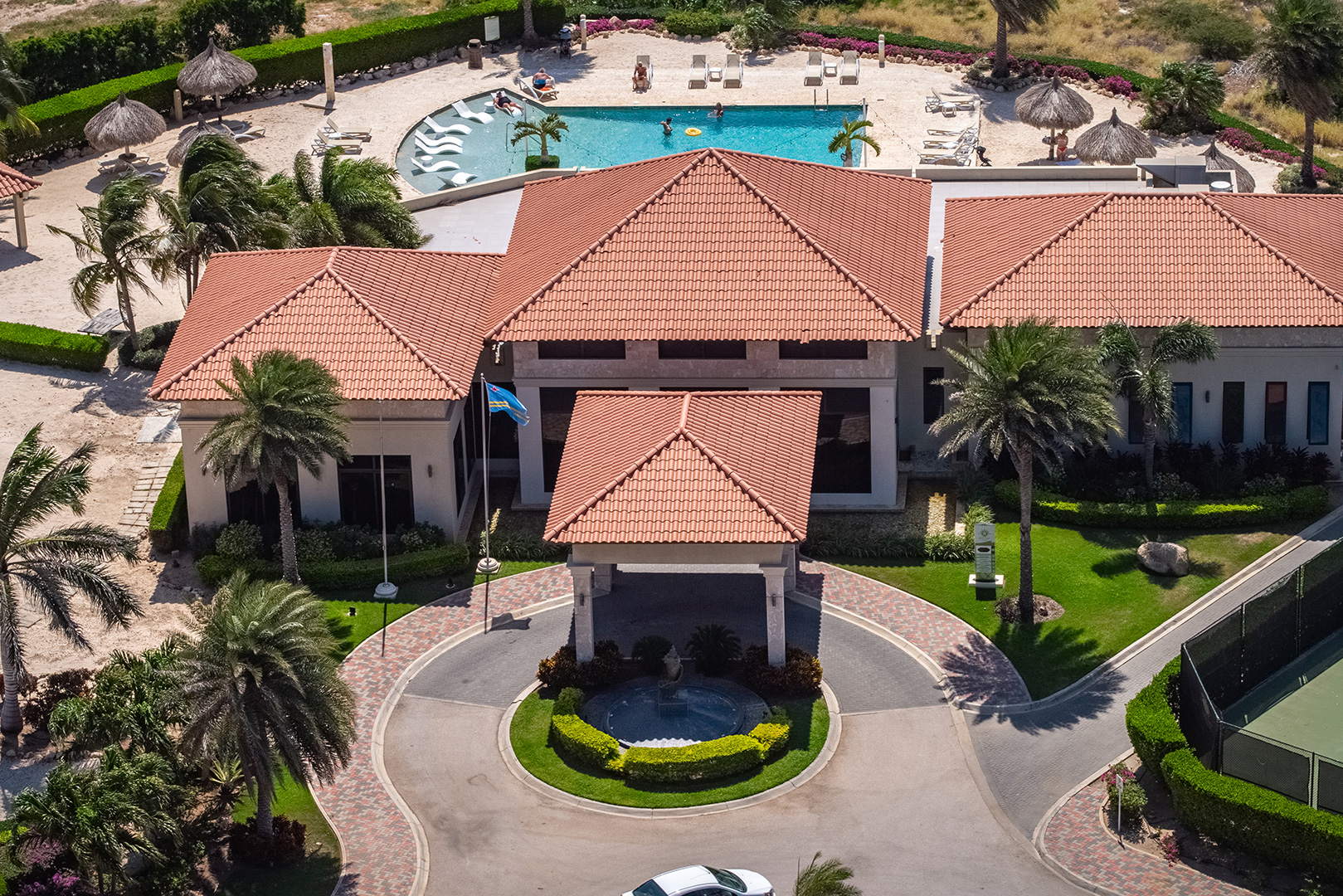 Aerial view of the Gold Coast Aruba clubhouse, swimming pool, and tennis court